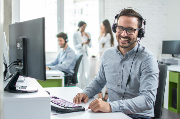  happy young man with headset smiling at camera - devicenow. True subscription worldwide
