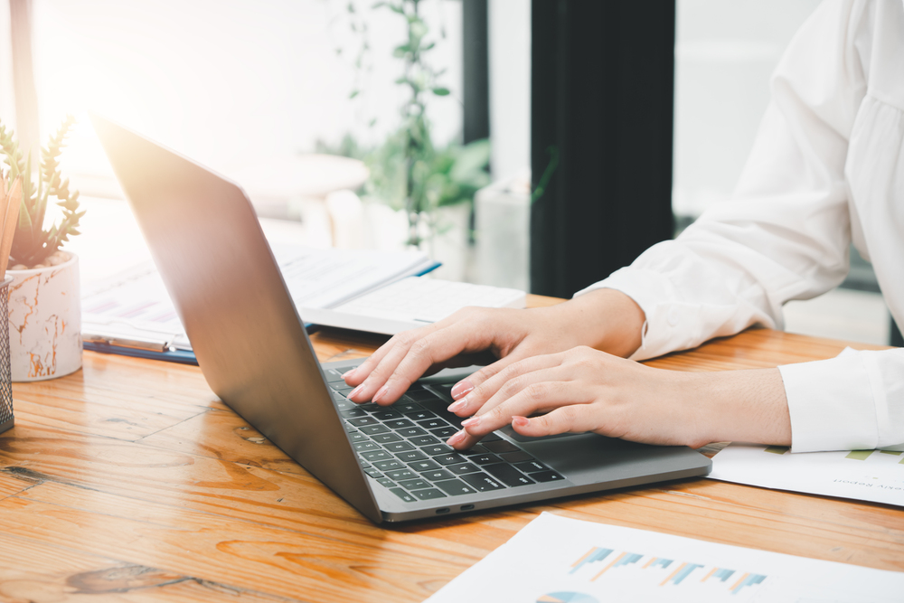 Bussinesswoman hand working on laptop computer at the table in t
